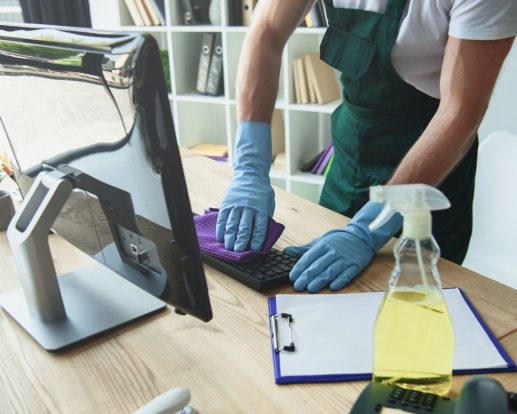 cropped shot of professional cleaner in rubber gloves cleaning computer keyboard in office cropped shot of professional cleaner in rubber gloves cleaning computer keyboard in office